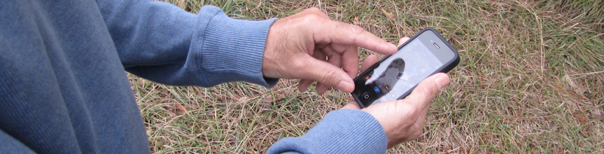 person using phone to find geocache