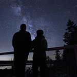 2 people looking at the dark night sky