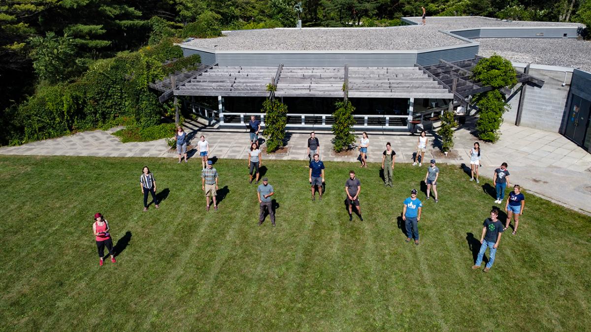 A group of arboretum staff standing on grass in front of the office.