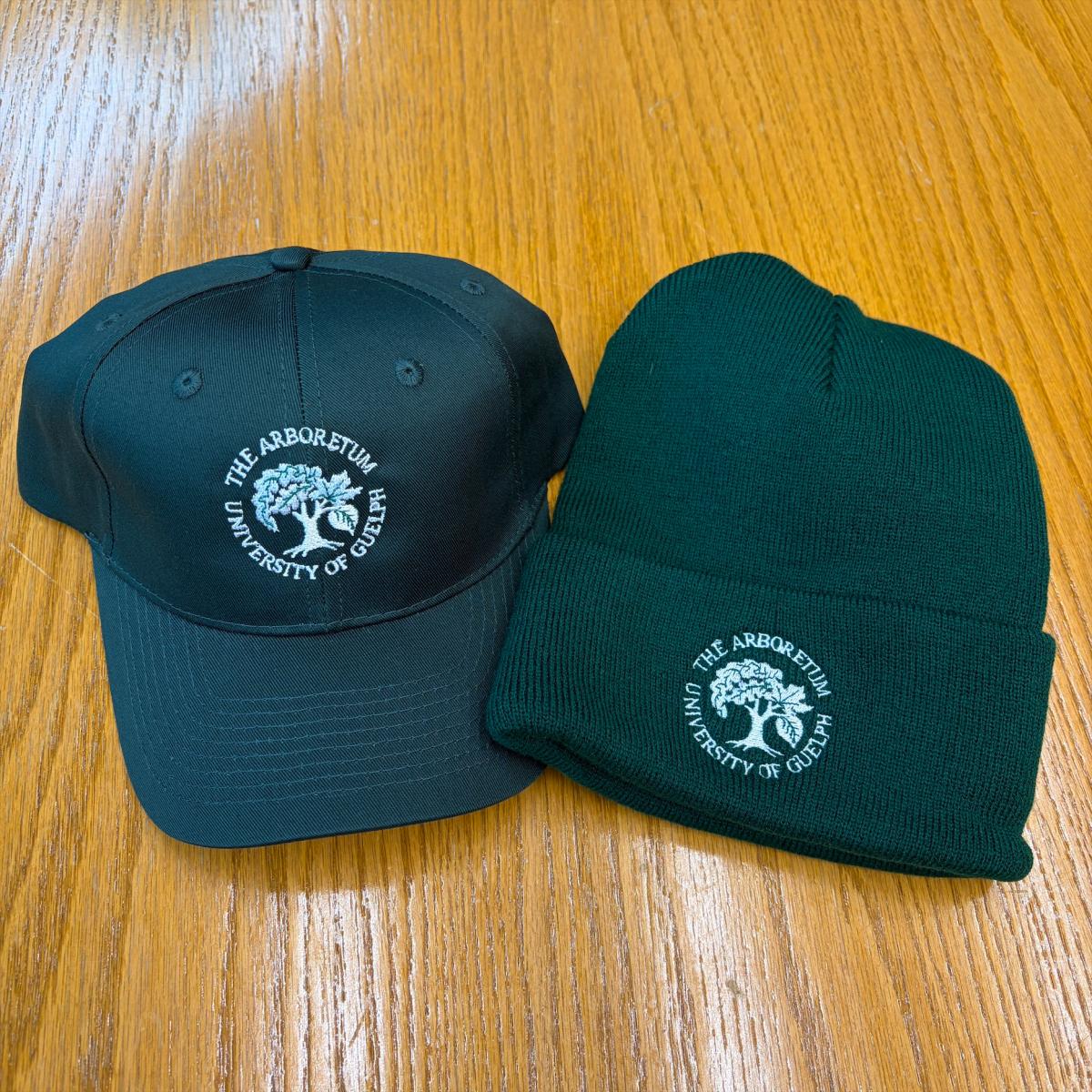 A Green Cap and a Green Beanie on a wooden table 
