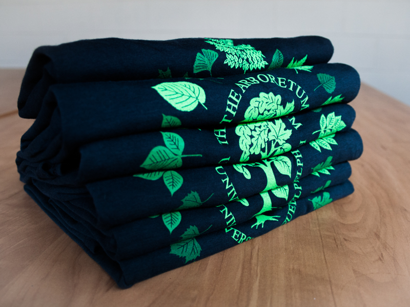 colour photo of t-shirts with The Arboretum logo